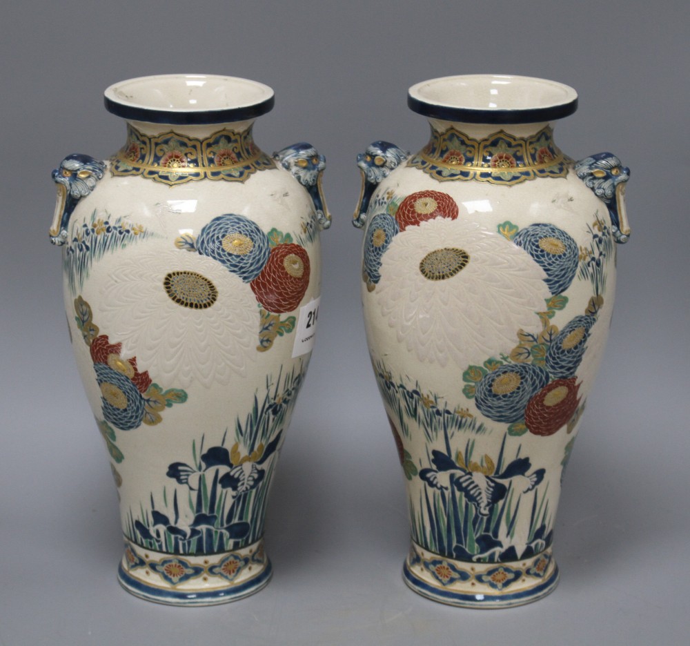 A pair of Satsuma vases, decorated with chrysanthemums, irises and storks, with beast head lug handles, height 31cm